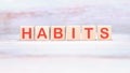 HABITS word made of wooden cubes on a light background