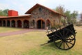 Hacienda colonnial country house, stone construction arches and wooden cart on the lawn