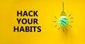 Hack your habits symbol. Green shining light bulb icon. Words `Hack your habits`. Beautiful yellow background. Business,