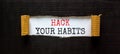 Hack your habits symbol. Words `Hack your habits` appearing behind torn black paper. Beautiful black background. Business,