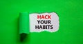 Hack your habits symbol. Words `Hack your habits` appearing behind torn green paper. Beautiful green background. Business,