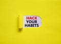 Hack your habits symbol. Words `Hack your habits` appearing behind torn yellow paper. Beautiful yellow background. Business,