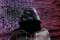 Hacker in an american hoody in front of a code background with binary streams and information security terms cybersecurity concept