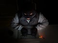 Hacker with balaclava typing on laptop Royalty Free Stock Photo