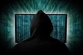 Hacker  behind glowing computer monitor display in front of green source binary code background internet cyber hack computer Royalty Free Stock Photo