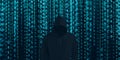 Hacker in black hood Shows the extraction through binary. Stand in front of a code background with binary streams and information Royalty Free Stock Photo