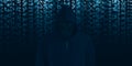 Hacker in black hood Shows the extraction through binary. Stand in front of a code background with binary streams and information Royalty Free Stock Photo