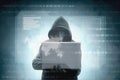 Hacker in black hoodie holding laptop with virtual display server data, chart bar, binary code and world map Royalty Free Stock Photo