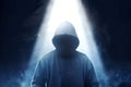 Hacker in black hoodie standing with smoke and light from the top Royalty Free Stock Photo