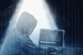 Hacker in black hoodie using laptop on the desk to hacking system with binary code and upload the malware Royalty Free Stock Photo