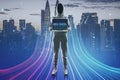 Hacker with computer and abstract glowing big data or metaverse hologram on blurry city background. Future, hacking and digital