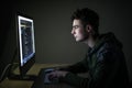 Young hacker in the dark breaks the access to steal information and infect computers and systems. concept of hacking and cyber ter