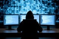 Hacker in dark hoodie working on multiple screens with code displayed Royalty Free Stock Photo