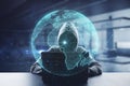 Hacker at desktop using laptop with creative glowing polygonal grid planet on blurry office interior background. Globe, hacking,