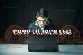 Hacker with a face is trying to steal cryptocurrency using a computer. Fraud and scam at Cryptojacking Royalty Free Stock Photo