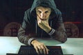 Hacker with a face is trying to steal cryptocurrency using a computer. Scam at Cryptojacking Royalty Free Stock Photo