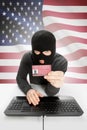 Hacker with flag on background holding ID card in hand - United States