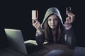 Hacker girl holding credit card violating privacy holding credit card in cybercrime and cyber crime Royalty Free Stock Photo