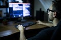 Hacker in headset and eyeglasses with keyboard hacking computer system