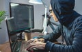 Hacker in a hood are programming virus code on a laptop. The concept of Internet fraud and personal data hacking Royalty Free Stock Photo