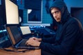 Hacker sitting at laptop, information hacking