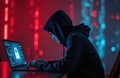 Hacker in hoodie uses laptop. Digital lock icon on screen. Coding, cybercrime, data breach, computer hacking. Dark web, malware, Royalty Free Stock Photo