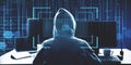 Hacker in hoodie using computer at desktop on abstract binary code background with face recognition interface. Hacking, ID and Royalty Free Stock Photo
