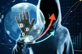 Hacker in hoodie using glowing globe hologram with financial arrows and money signs on blurry background. Digital world, hacking, Royalty Free Stock Photo