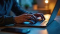 Hacker intently types on laptop keyboard in dimly lit workspace, late evening. Focused concentration on programming, coding, Royalty Free Stock Photo