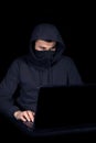 Hacker with laptop initiating cyber attack,  on black Royalty Free Stock Photo