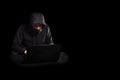 Hacker with laptop initiating cyber attack,  on black Royalty Free Stock Photo