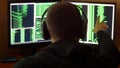 Hacker is looked to binary code. Criminal hacker penetrating network system from his dark hacker room. Hacker stealing Royalty Free Stock Photo