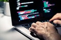 Hacker with malware code in computer screen. Cybersecurity, privacy or cyber attack. Programmer or fraud criminal writing.