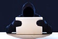 Hacker man in black hood and mask with computer laptop hacking system in digital intruder cyber crime concept Royalty Free Stock Photo