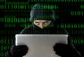 Hacker man in black using computer laptop for criminal activity hacking password and private information