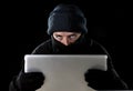 Hacker man in black using computer laptop for criminal activity hacking password and private information