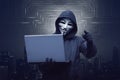 Hacker man with mask holding laptop while appoint