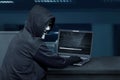 Hacker man wearing mask using laptop to upload computer virus