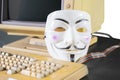 Hacker mask on desk with computer