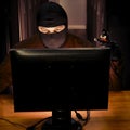 Hacker near server equipment in hand with wires for hacking. Concept of network security problems and hacker attacks on databases Royalty Free Stock Photo