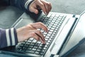 Hacker the programmer is typing on the keyboard of the laptop to hack the system. Royalty Free Stock Photo