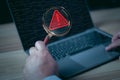 Hacker or programmer using laptop with triangle caution warning sign, coding, cryptography Royalty Free Stock Photo