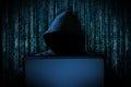 Hacker with red glowing mask behind notebook laptop in front of blue source binary code background internet cyber hack attack Royalty Free Stock Photo