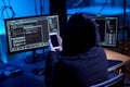 hacker with smartphone and computers in dark room Royalty Free Stock Photo
