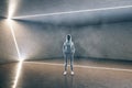 Hacker standing in contemporary concrete futuristic gallery interior
