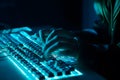 Hacker uses keyboard, shakes buttons with fingers to crack password. Internet security concept, cyber attack. Neon blue