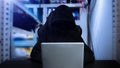 Hacker using computer with digital interface while sitting at desk of blurry interior. Hacking and thief concept Royalty Free Stock Photo