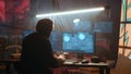 Hacker using computer to run malicious code in foggy dark basement Royalty Free Stock Photo