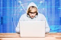 Hacker using a laptop with a blue digital background Royalty Free Stock Photo