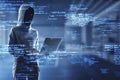 Hacker using laptop with creative coding html language on blurry office interior background. Web developer, hacking, malware and
